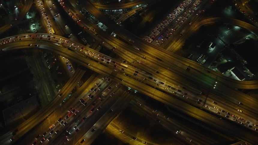 Aerial panorama of a highway in the middle of a metropolitan city with vehicle traffic at night
