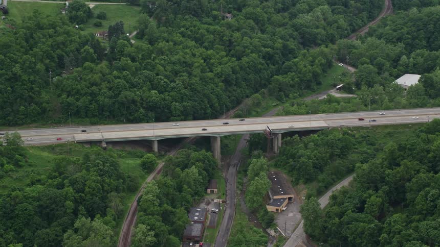 Aerial panorama of a highway on a bridge over mountains with vehicle traffic