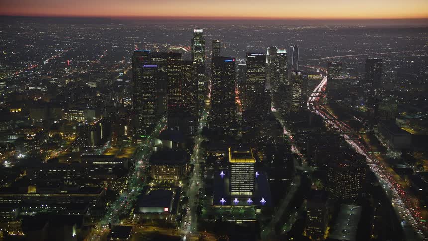 Busy city streets enclose a lighted metropolis at dusk