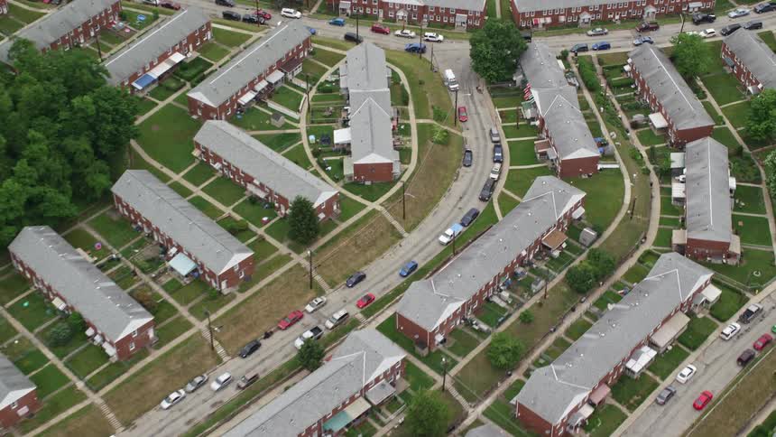 Aerial view of a residential area with redbrick buildings and cars parked along the streets