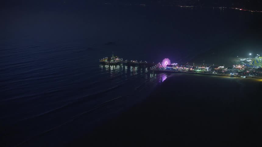 A carnival is on the pier by the city