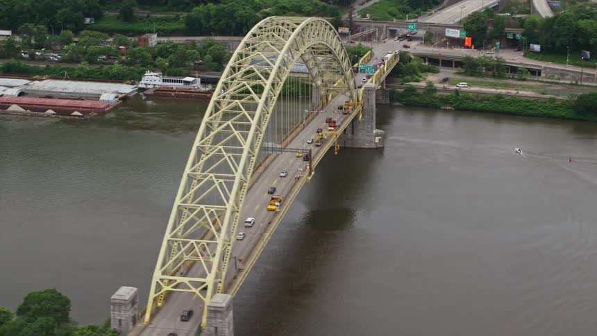 Traffic crosses bridge over river near docked barges