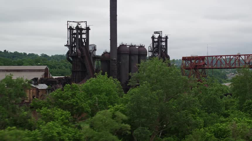 Aerial view of the exterior of a factory by a river