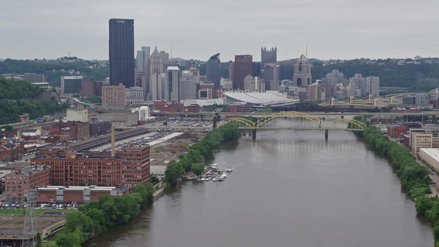 Aerial panorama of a metropolis with large buildings next to a river canal with bridges on a cloudy day