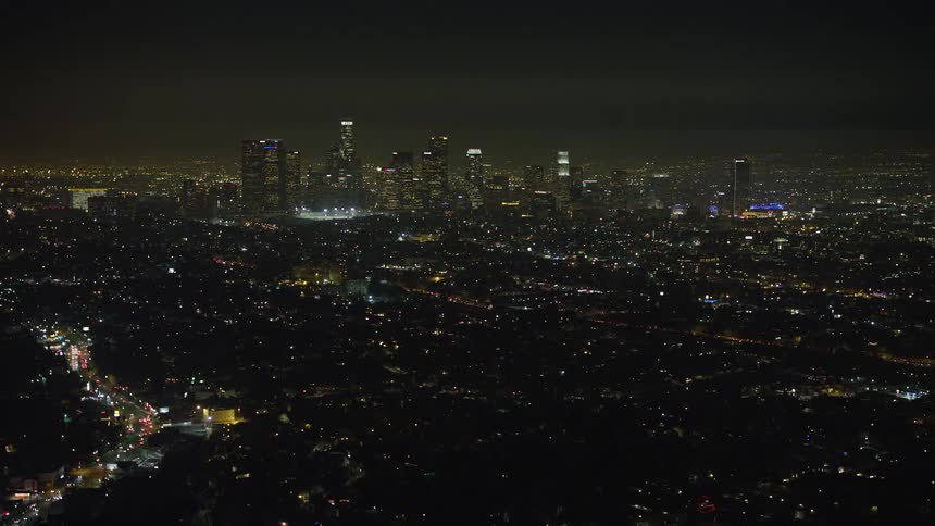 Aerial panorama of a metropolis at night with buildings and urban areas illuminated by lights