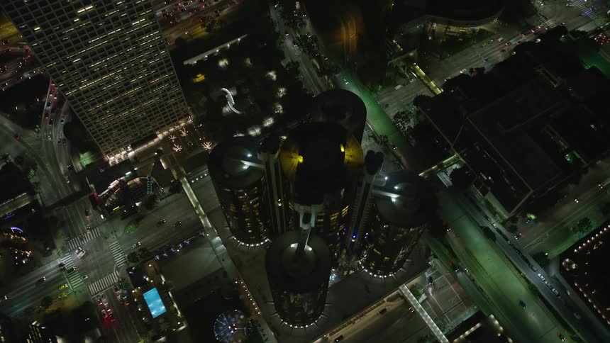 Aerial panorama of a metropolis with a modern skyscraper and vehicle traffic through the streets at night