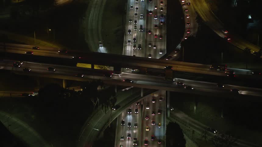 Aerial panorama of highways at an intersection with vehicle traffic at night