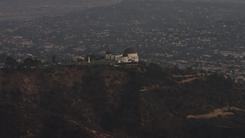 Aerial panorama of a monastery on the peak of a mountain and an urban city on the horizon