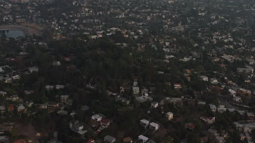 Aerial panorama of a residential city built on hills and mountains with vegetation