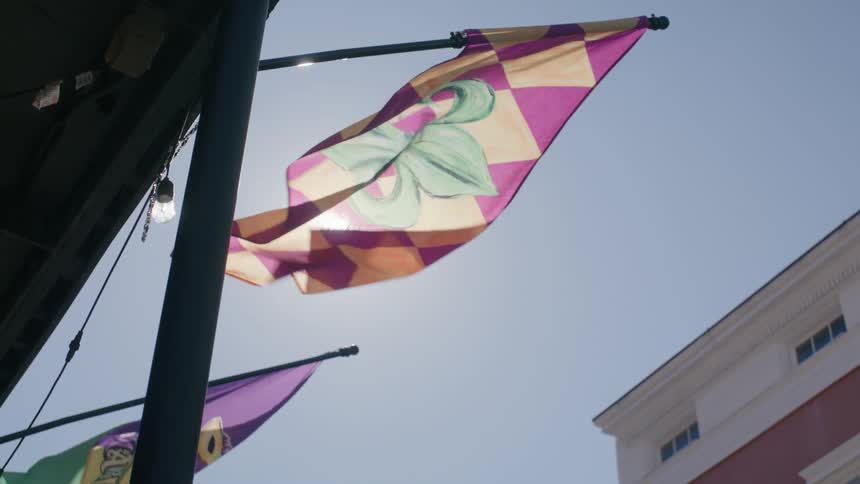 Flags on the exterior of a building with sun reflection on a cloudless blue sky day