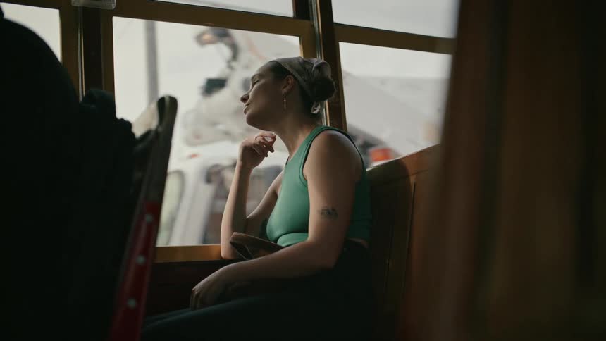 Woman sitting on public transport while enjoying the view through the window