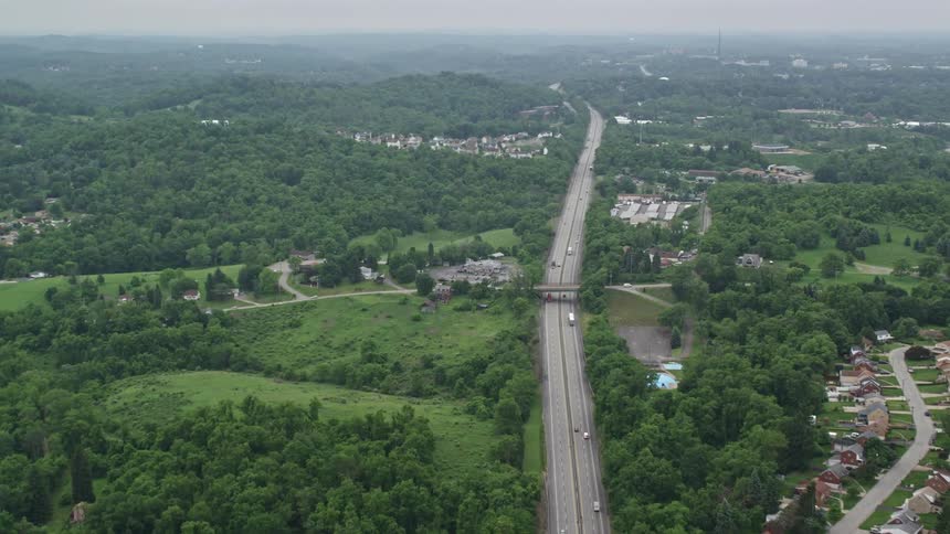 Vehicles travel a long a freeway that passes near a sprawling community