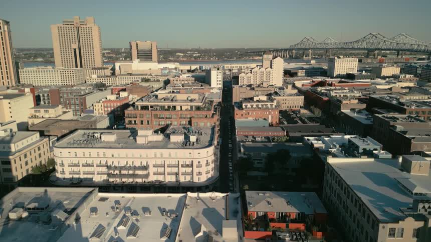 Blocks of buildings in a city in front of a long tall bridge in the distance