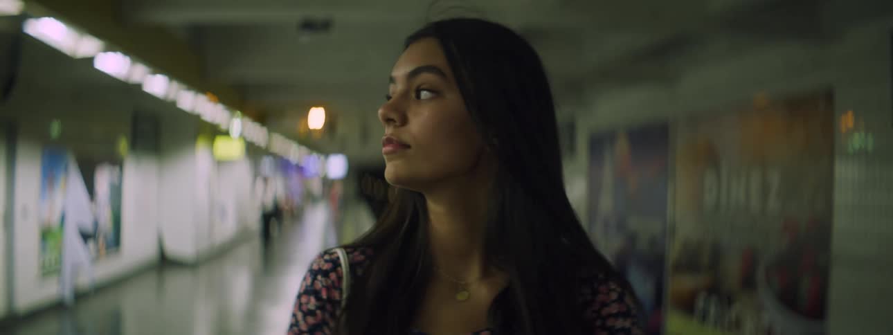 Young girl looks around on the corridor of a terminal or subway