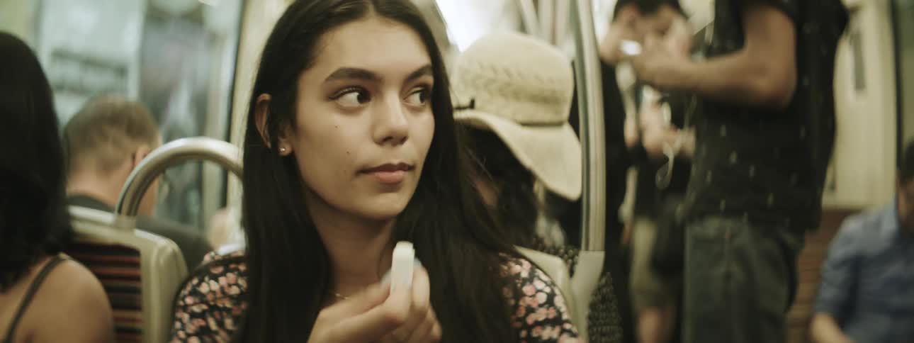 Woman applies lip balm while riding a bus