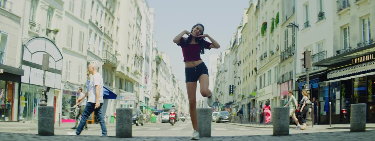 A woman poses in the middle of a busy street in Paris