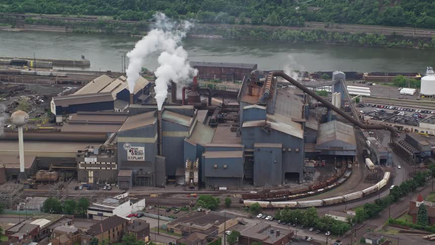 An aerial clip of a factory close to a river