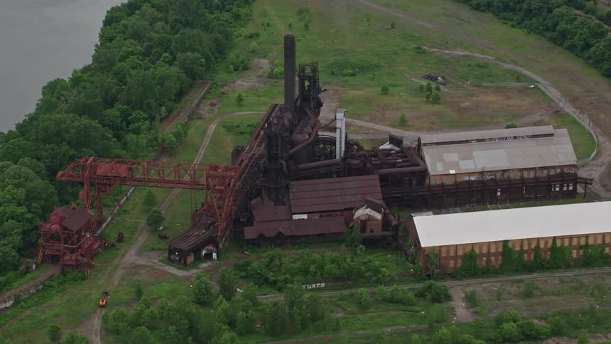 A lumber mill sits abandoned in a wide open space near the river