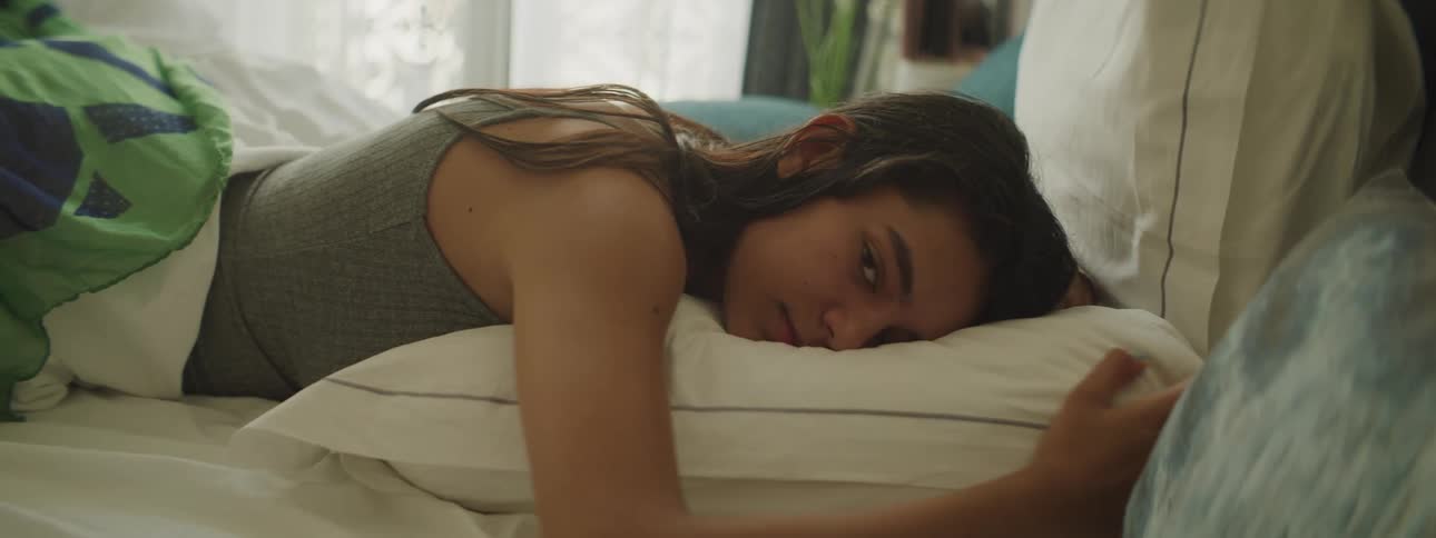 Young woman sleeping in bed and then waking up