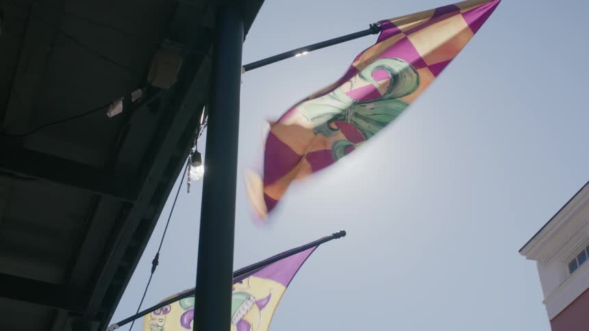 Flags hanging from the roof of an establishment with solar reflection on a cloudless blue sky day