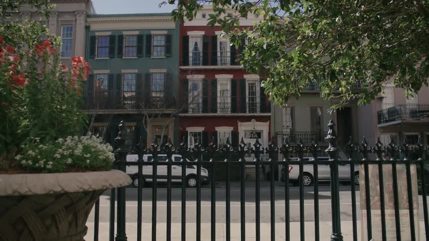 Facade of residential buildings facing a street with vehicle and pedestrian traffic