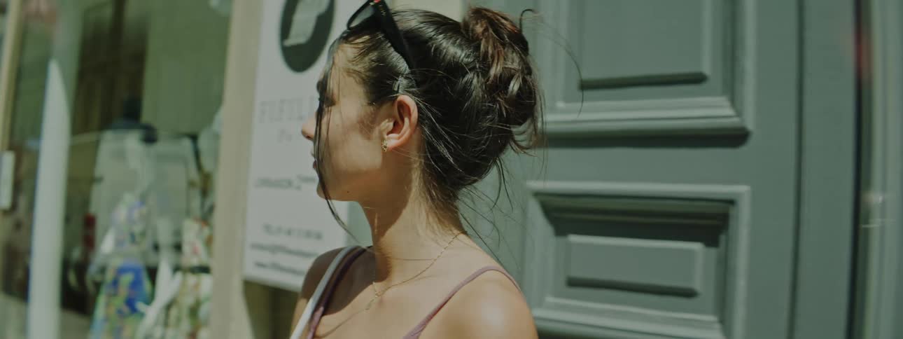 Young woman coming out of a building in the city on a sunny day