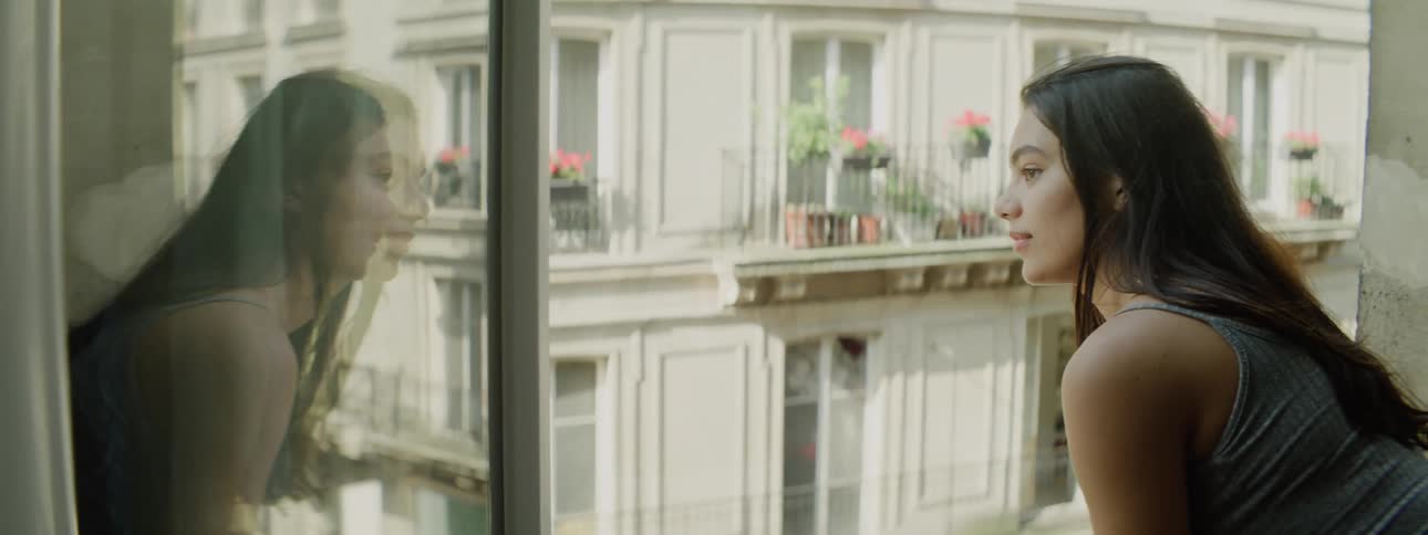 Young woman drinks coffee on a balcony
