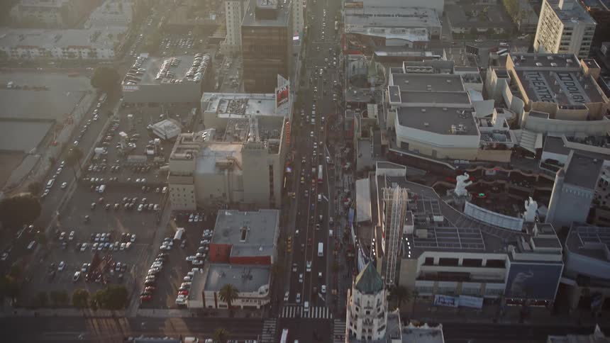 Aerial panorama of a metropolis with urban and commercial buildings and views of streets with vehicle traffic and solar reflection