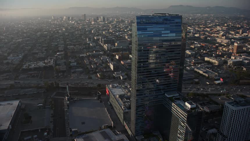 Aerial panorama of a modern mirrored commercial building on the edge of a stadium in a metropolis