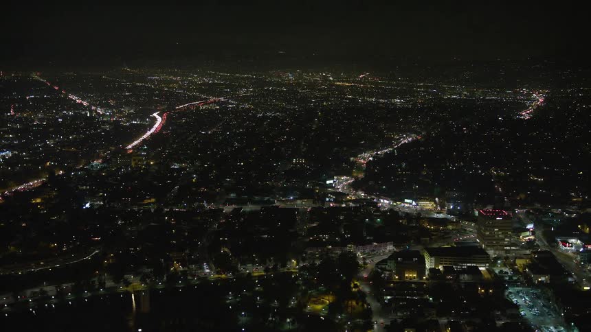 An aerial view of a large city at night with lots of residential lights