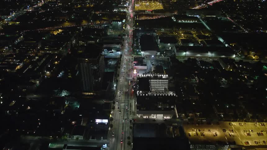 Aerial view of city streets and neighborhood rooftops at night