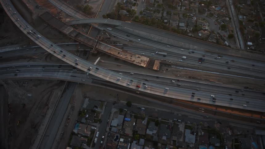 An aerial view of a highway interchange with multiple lanes and cars