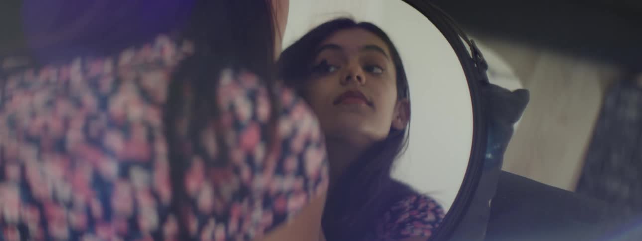 A teenage girl applies makeup