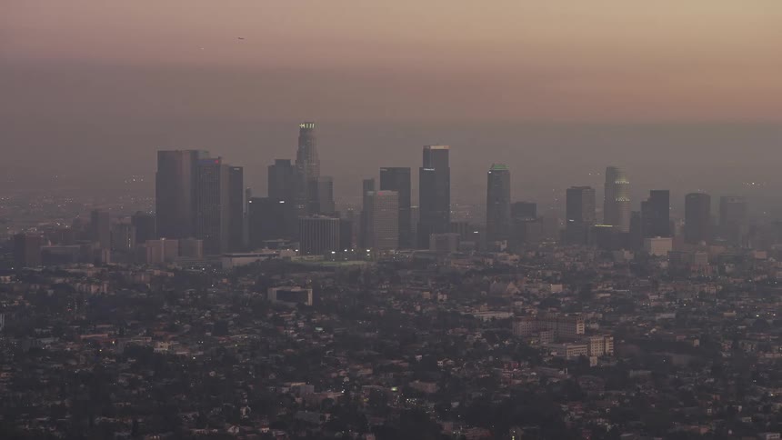 Panorama of a metropolis like modern skyscrapers and residential neighborhoods on a foggy day and an orange sky