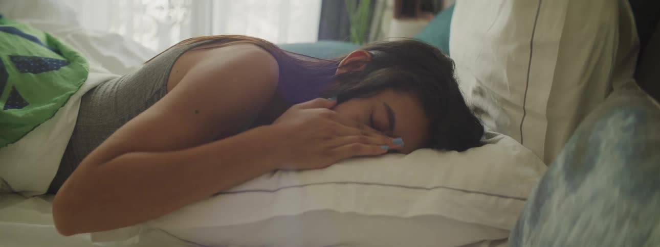 Young woman sleeping on her stomach and then waking up