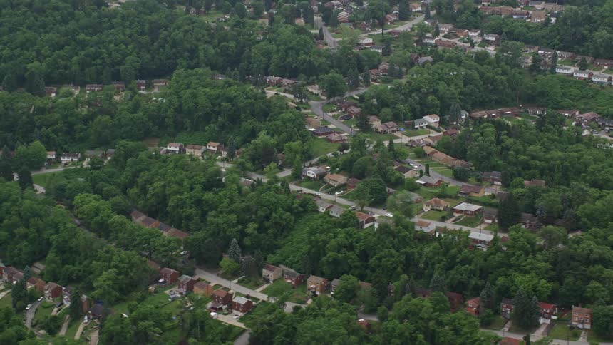 Aerial view of a residential area surrounded by lush green trees