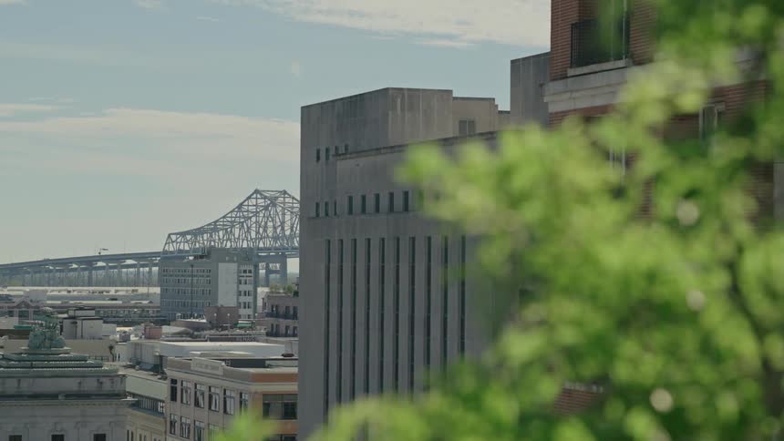 Commercial and residential buildings with a bridge in the background on a blue sky day with clouds
