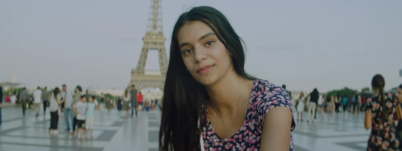 Portrait of a smiling young woman while standing in an eiffel tower square