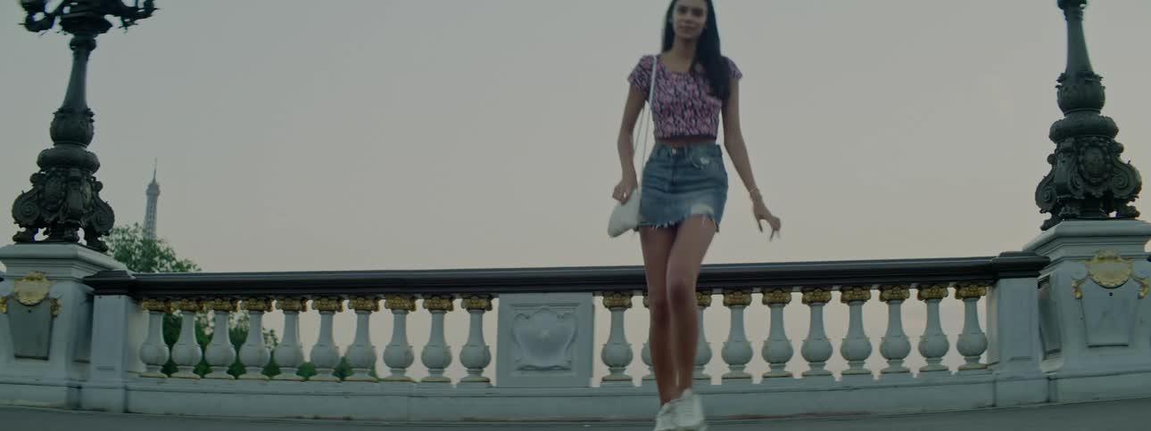 A young woman poses for the camera on a bridge