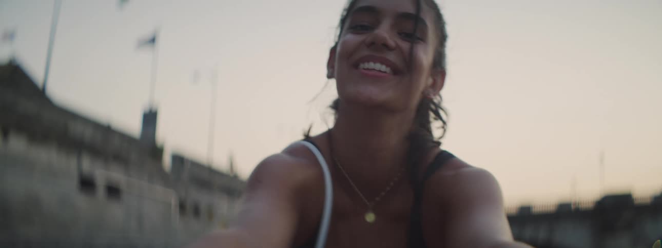 Young girl playfully looks at the camera at evening in the city