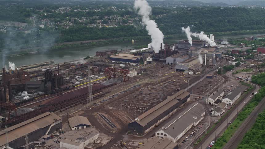 Panorama of a factory in operation emitting smoke on the edge of a lake