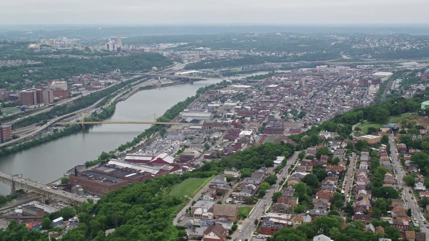 Aerial view of a large city near a river and over a hill