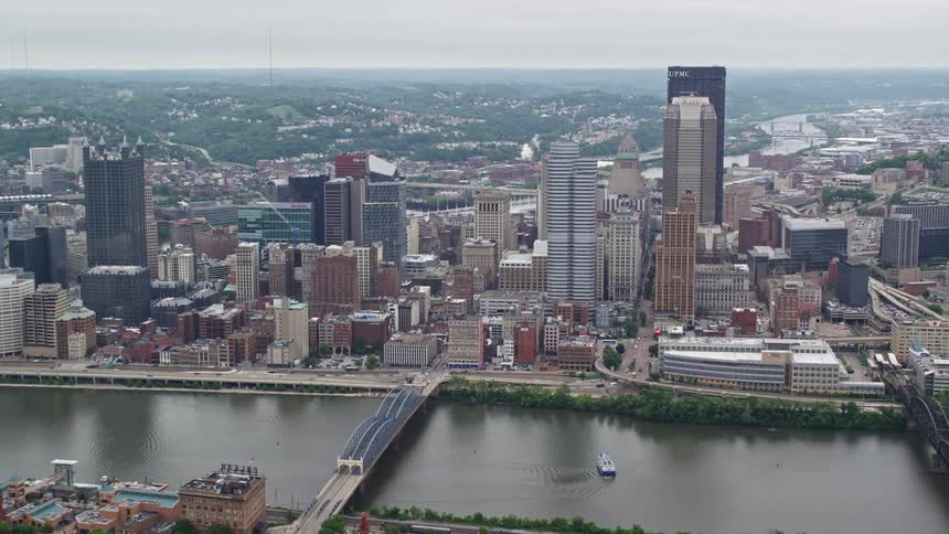 Several tall buildings line a river that runs through a metropolitan city