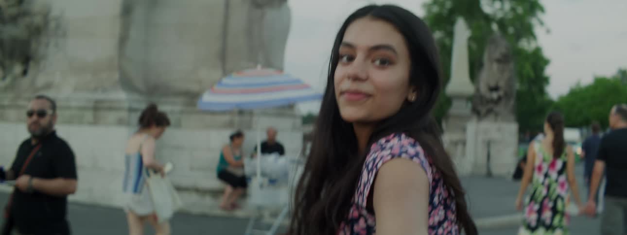Portrait of a young woman walking and taking selfie through the streets of france