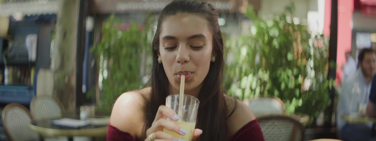 A woman takes a drink from her glass