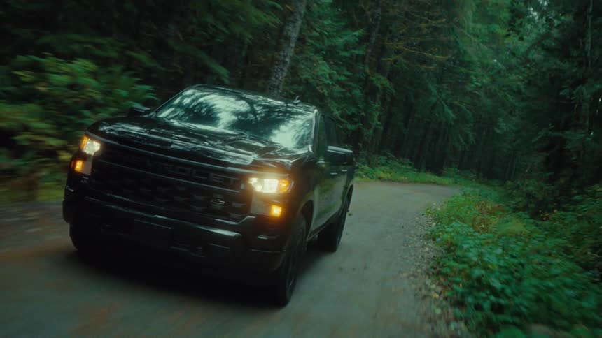 Pickup truck moving on a road in the middle of a forest