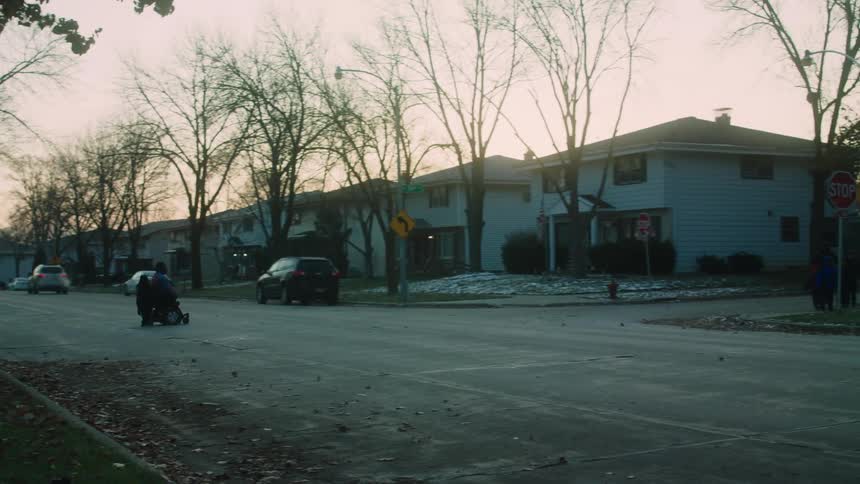 A motorized wheelchair crosses the street