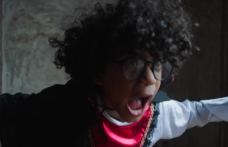 Young little boy waving his arms and screaming while wearing a silk outfit