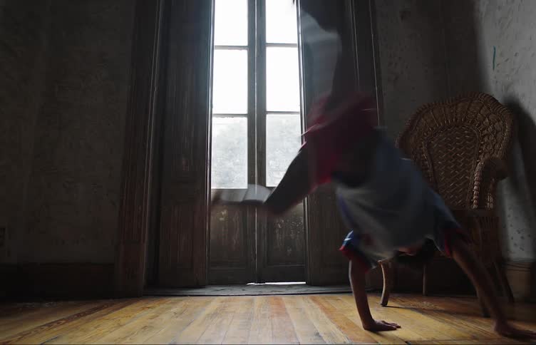 Little boy indoors doing a cartwheel