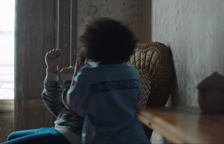 Father sitting on a chair pretending to be attacked by his sons little boy while they play